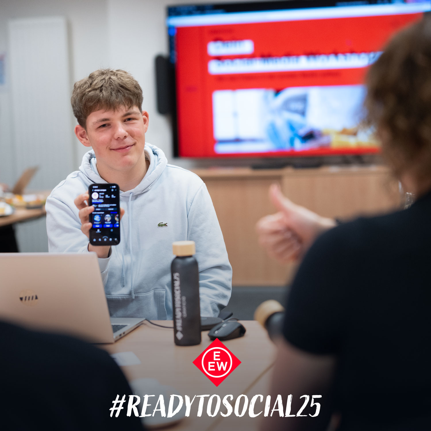 Junger Azubi zeigt Handy beim Social Media Workshop im Rostocker Überseehafen